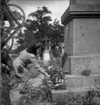 Frenchwoman placing flowers on a memorial during a Mass celebrating Bastille Day 13-Jul-44