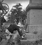 French child placing flowers on memorial during a Mass celebrating Bastille Day 13-Jul-44