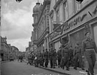 Soldiers of the Canadian Army Occupation Force (C.A.O.F.) walking around Aurich, Germany, ca. 26-27 August 1945 [ca. August 26-27, 1945].