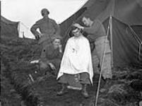 An unidentified infantryman of Le Régiment de Hull getting a haircut, Kiska, Aleutian Islands, August 1943 August 1943.