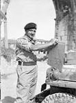 Lieutenant-General E.L.M. Burns, General Officer Commanding 1st Canadian Corps, consults his map en route to Rimini, Italy, 23 September 1944 September 23, 1944.
