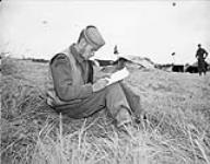 Able Seaman George Vilneff, W-1 Party, Royal Canadian Navy Beach Commando "W", writing a letter in the Juno sector of the Normandy beachhead, France, 20 July 1944 20-Jul-44
