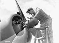 A mechanic servicing the port engine of a Lockheed Hudson aircraft of the Royal Air Force (R.A.F.) Ferry Command, Dorval, Québec, Canada, 13 May 1942 May 13, 1942