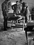 Le personnel du Corps de santé royal canadien examine un soldat canadien blessé que l'on transporte à une Unité chirurgicale de campagne 15 janvier 1944.