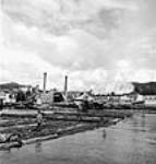 Des flotteurs poussent les billes des allingues jusqu'au bassin de flottage en aval du moulin de la Powell River Company juil. 1944