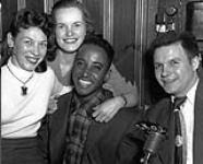 Singer Tommy Edwards (centre) with two fans and radio announcer from CKOY. Photograph taken at the Standish Hotel the night of a performance ca. 1950.