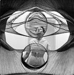 [Woman looking at a geometric string sculpture] n.d.