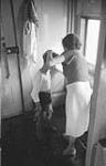 A new life in a new land. Before meeting Dad a boy is slicked up by his sister in the somewhat skimpy washroom facilities of the immigrant train colonist car September 15, 1951