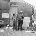 Sam Crow and his son [Paulossie Sukk Nuktie] at the Richmond Gulf Hudson's Bay Company outpost, Richmond Gulf (Tasiujaq) 1949