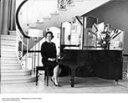 Patricia Kathleen (P.K.) Page sitting at a piano May 1957