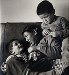 [Sam and John Houston playing with family friend Mackituk, Kinngait, Nunavut] [between 1956-1960]