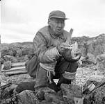 [Tudlik creating a soapstone carving, Kinngait, Nunavut] 1960