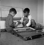 [Sam Houston (left) and Isachee (right) playing with toys, Kinngait, Nunavut] [between June-September 1960].
