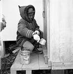 [Kananginak Pootoogook painting a door, Kinngait, Nunavut] [between 1956-1960]