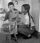 [Woman and Sam Houston (left) baking, Kinngait, Nunavut] [between 1956-1960]