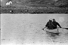 [Mackenzie Porter (left) and a man paddling a boat] [between 1956-1960]