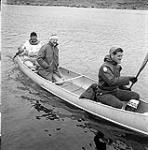 [A man, Mackenzie Porter (middle), and James Houston (right) on a canoe, Iqaluit, Nunavut] 1960