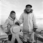 [Sarpinak (left) and his father Pitseolak (right) steering a boat, Iqaluit, Nunavut] 1960