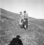 Two women, a boy and a girl walking outside, Kinngait, Nunavut] 1960