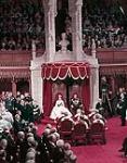 Queen Elizabeth II and Prince Phillip sit on thrones before a full Parliament 14 octobre 1957.