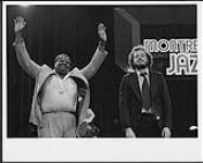 Oscar Peterson et un musicien non identifié se faisant applaudir au Festival de jazz de Montreux [between 1975-1980].