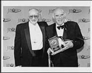Walt Grealis et Dan Gibson exhibant the Walt Grealis Special Achievement Award, un prix reçu lors de la cérémonie de remise des Juno [ca. 1997].