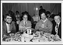 Walt Grealis et trois dirigeants de l'industrie de la musique non identifiés assis à une table [between 1975-1980].
