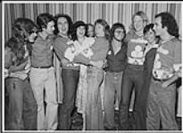 Personnel de la station radio CFRW, Winnipeg, conférence de presse de Trooper, (de gauch à droite) Tommy Stewart, Brian Smith, Doni Underhill, Trish (CFRW), Robbie Piel (CFRW), Gary Bulette (CHIQ FM), Frank Ludwig, Judy (coordonnatrice de la promotion, CFRW), Ra McGuire [entre 1975-1980].