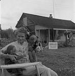 Mme Betsy Howard devant sa maison July 1956.