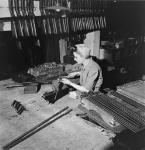 Female worker Edna Rorabeck fits the bolt action to a .22 calibre training rifle in the H.W. Cooey Co. Ltd. plant mai 1944