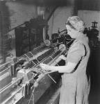 Female worker Mrs. Audrey Rollings drills .22 calibre training rifle barrels on a lathe in the H.W. Cooey Company Ltd. munitions plant May 1944