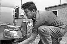 [Councillor Bennett Brant, Kanien'keha:ka (Mohawk) from Tyendinaga, repairing a car] [ca. 1959]