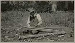 [Anishinaabe man making snowshoes] 1920