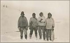 [Four Innu men standing outside at Emish (Voisey's Bay), identified from left to right: Nabeé one; Peeuju naeeone; Steamah; Pukwee] [between 1921-1922]
