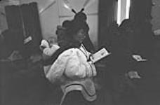 [Komoratuk Mathewsie and her baby attending a service at St. John Anglican Church, Cape Dorset (Kinngait)] November 1980
