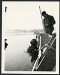 [Man in diver's suit and helmet doing underwater work for Champlain Bridge construction] cira 1924-1928.