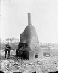 Burning up rubbish. A field incinerator. May, 1916. May, 1916