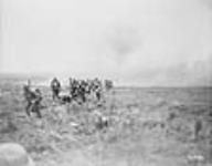 Canadian troops advancing through a German barrage east of Arras. Sep., 1918.