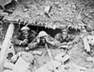 Three black soldiers in a German dug-out captured during the Canadian advance east of Arras  October, 1918.