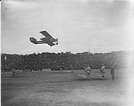 [Caproni Ca33 aircraft of L'Armee de l'Air flying over the Canadian baseball team at the Inter-Allied Games, Pershing Stadium, Paris, France, July 1919.]. 1919.