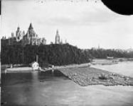 Raft of timber on the Ottawa River [with view of Parliament Hill]  [1859 - 1916].