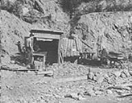 Small shaft placer operation, Nutall descends shaft shile partner starts pump near Barkerville, B.C 1938