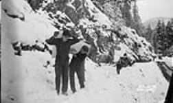 (Relief Projects - No. 101). Transporting supplies over a rock slide at mile 14. Feb. 1934