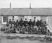 Le révérend Edmund Peck et un groupe d'Inuits, île Blacklead, baie Cumberland. [L'homme debout à la gauche du révérend Peck est Peter Tulugarjuaq. L'homme dans la rangée arrière à l'extrême droite est Nattiapik, un ancêtre de la famille Kilabuk] [5 septembre 1903]