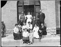 Staff outside the entrance of the Brandon Indian Industrial School. ca. 1935 - 1940