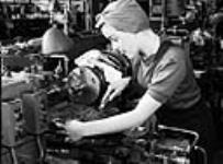 Veronica Foster, une employée de la société John Inglis Co. Ltd. connue sous le nom de « la fille au fusil-mitrailleur », conduit un tour sur la chaîne de production de fusils-mitrailleurs Bren. 10 mai 1941