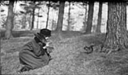 Edna [Boyd] photographing a black squirrel in High Park, [Toronto, Ont.], 24 March, 1917. March 24, 1917.