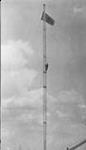 Man climbing wireless mast flying Union Jack, n.p., n.d.