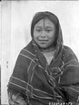 Close-up of a young Inuit girl wearing a plaid shawl, Kuujjuarapik (Nunavik), Quebec
  Aug. 1927.