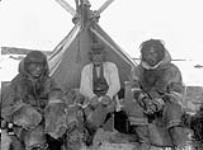 Group of unidentified Inuit men [left to right: Wahdi, Chester, Walung] in front of skin tent, Depot Island, [N.W.T.] June, 1926  June 1926.